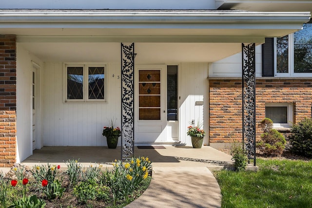 property entrance featuring brick siding and a porch
