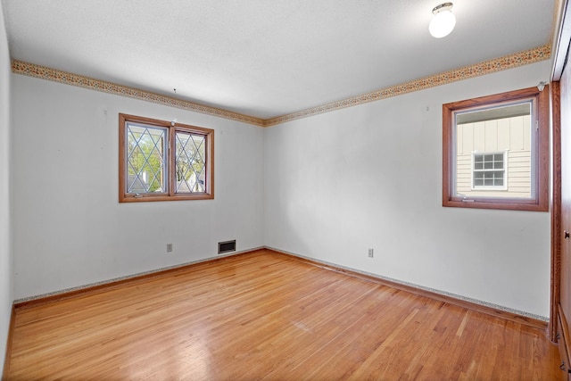 spare room featuring wood finished floors and baseboards