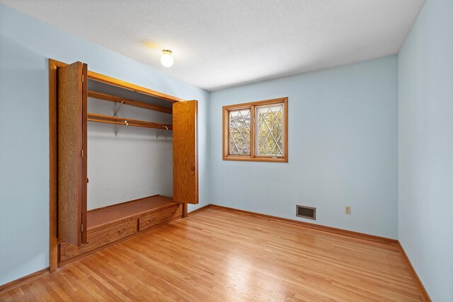 unfurnished bedroom with light wood-style floors, a closet, and baseboards