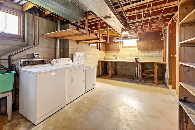 clothes washing area with washer and clothes dryer and a workshop area