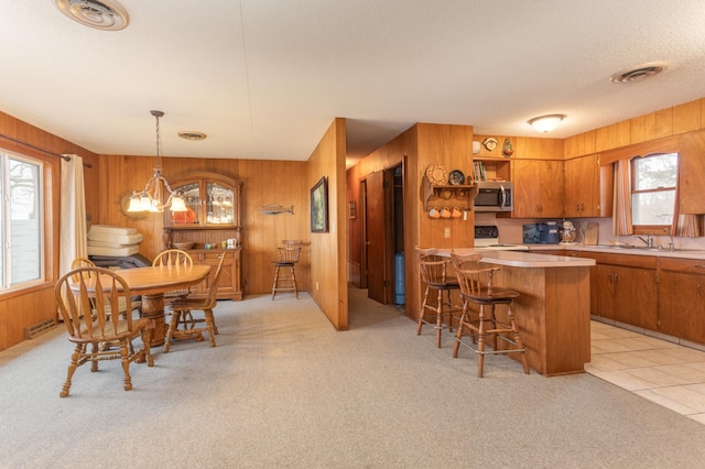 8236 Lake Carlos Dr NE, Carlos, MN 56319 - dining room with a chandelier, light colored carpet, and wood walls