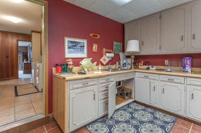 8236 Lake Carlos Dr NE, Carlos, MN 56319 - kitchen featuring a sink, light countertops, white cabinetry, wooden walls, and light tile patterned flooring