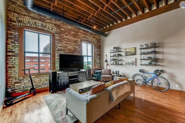 living area featuring brick wall and wood-type flooring