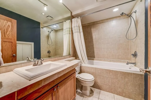 bathroom featuring vanity, tile patterned flooring, toilet, visible vents, and tiled shower / bath combo