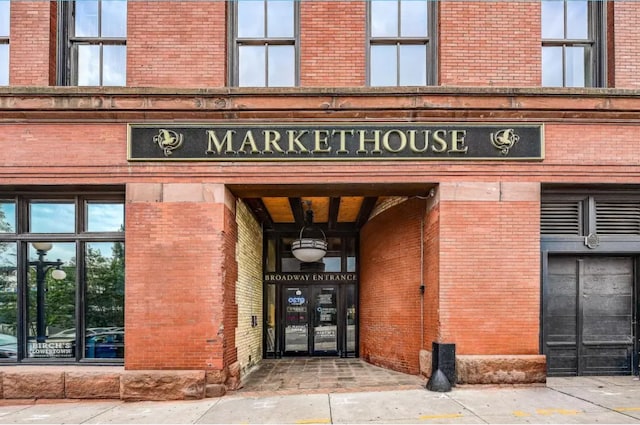 view of exterior entry featuring brick siding