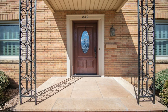 view of exterior entry with brick siding