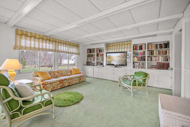 carpeted living room featuring beamed ceiling and built in shelves