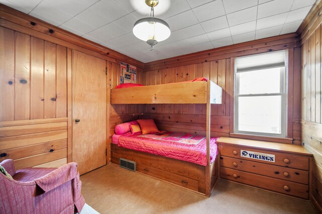 bedroom featuring wood walls