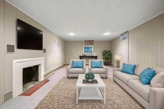 carpeted living room with a fireplace and crown molding