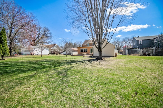 view of grassy yard featuring a residential view and a garage