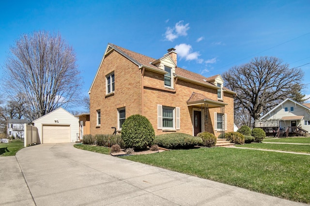 traditional-style house featuring an outdoor structure, a chimney, brick siding, a detached garage, and a front lawn