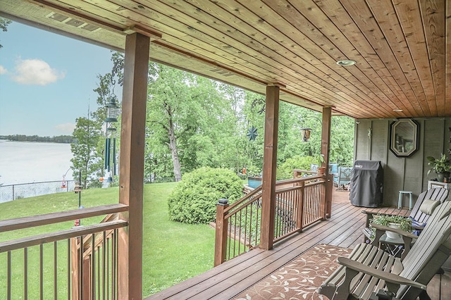 exterior space featuring a water view, fence, a yard, and area for grilling