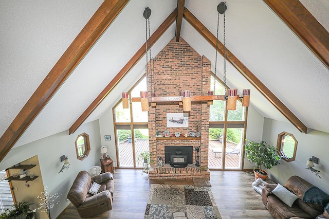 living area with beam ceiling, high vaulted ceiling, wood finished floors, and a brick fireplace