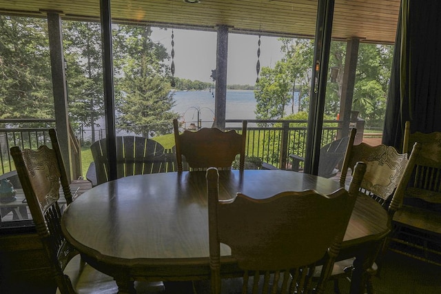 sunroom featuring a water view