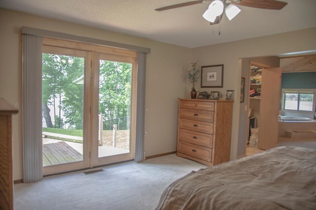 bedroom with access to outside, ensuite bathroom, ceiling fan, a spacious closet, and light carpet
