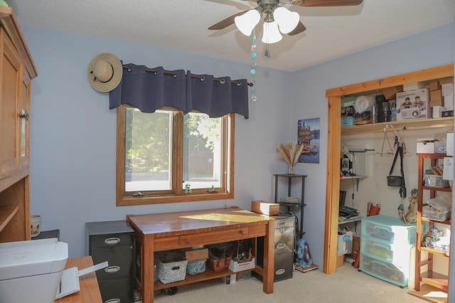 carpeted home office featuring a ceiling fan