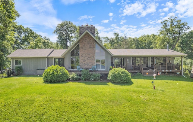 back of house with a chimney, a shingled roof, and a lawn