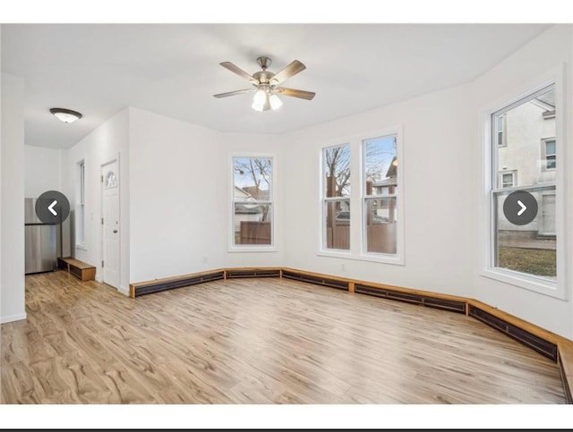 unfurnished living room with baseboards, a ceiling fan, and wood finished floors