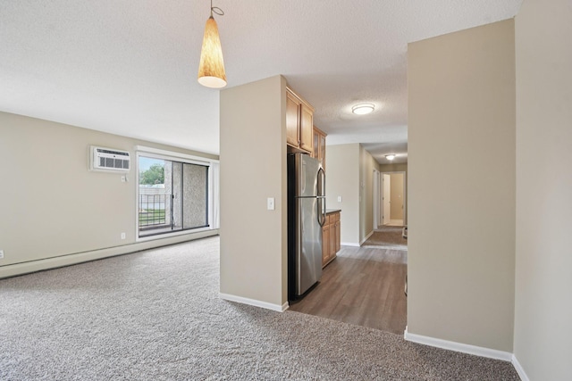 4110 Rahn Rd Unit 124, Eagan, MN 55122 - spare room featuring carpet floors, a textured ceiling, a wall unit AC, and a baseboard heating unit