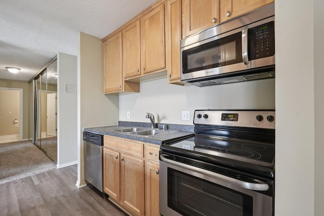 4110 Rahn Rd Unit 124, Eagan, MN 55122 - kitchen featuring appliances with stainless steel finishes, light brown cabinetry, dark wood-style flooring, dark countertops, and a textured ceiling