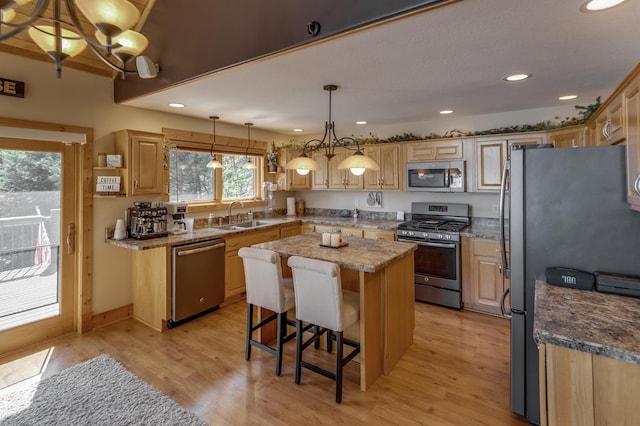 31690 Large Pine Trl, Laporte, MN 56461 - kitchen with stainless steel appliances, a sink, a center island, light wood-style flooring, and a breakfast bar