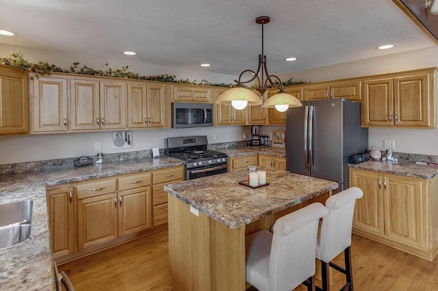31690 Large Pine Trl, Laporte, MN 56461 - kitchen with stainless steel appliances, a center island, light wood finished floors, a kitchen breakfast bar, and recessed lighting
