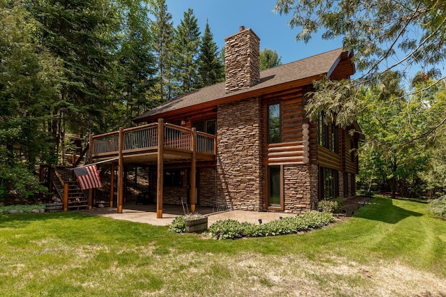 31690 Large Pine Trl, Laporte, MN 56461 - back of house with a patio, stone siding, a lawn, a chimney, and a deck