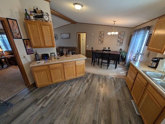 kitchen with a chandelier, lofted ceiling with beams, light countertops, and dark wood finished floors