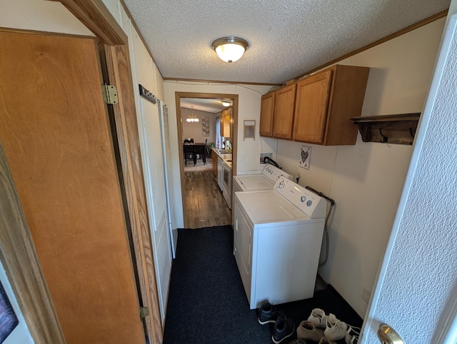 laundry area with cabinet space, washer and clothes dryer, a chandelier, and a textured ceiling