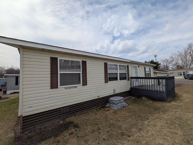 rear view of house with a yard and a wooden deck