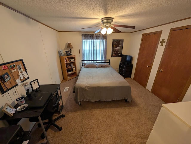 carpeted bedroom with ornamental molding, ceiling fan, two closets, and a textured ceiling