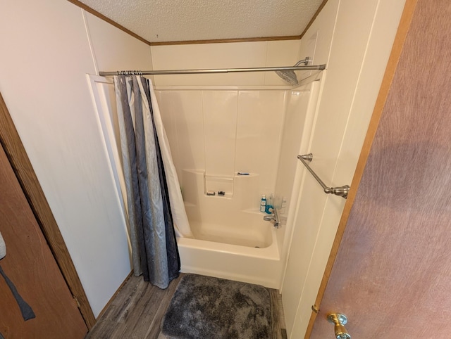 full bathroom featuring shower / bath combination with curtain, a textured ceiling, ornamental molding, and wood finished floors