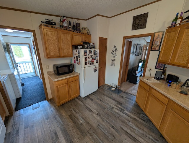 kitchen featuring ornamental molding, light countertops, freestanding refrigerator, black microwave, and dark wood-type flooring