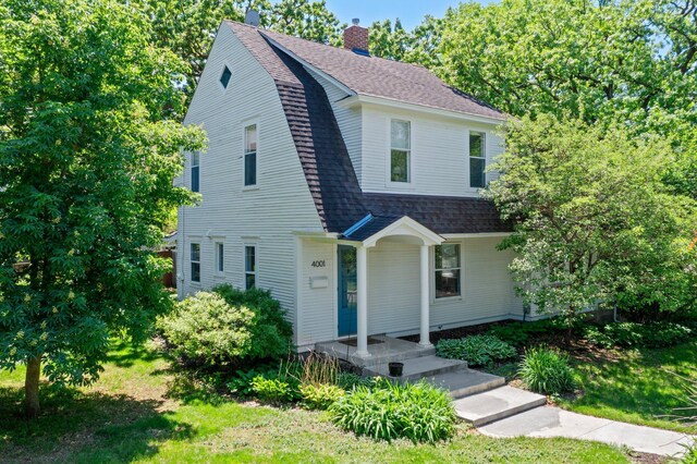 4001 Sheridan Ave S, Minneapolis, MN 55410 - colonial inspired home featuring a chimney, roof with shingles, and a gambrel roof