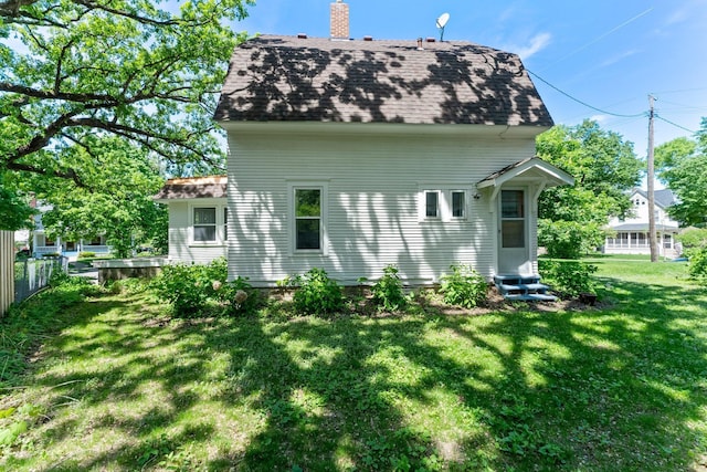 4001 Sheridan Ave S, Minneapolis, MN 55410 - rear view of house featuring a shingled roof, entry steps, and a chimney