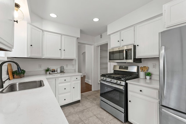 4001 Sheridan Ave S, Minneapolis, MN 55410 - kitchen with stainless steel appliances, a sink, light tile patterned floors, light countertops, and white cabinetry