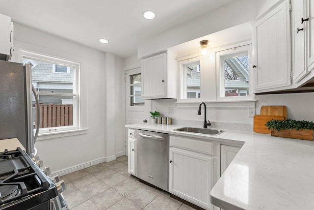 4001 Sheridan Ave S, Minneapolis, MN 55410 - kitchen featuring stainless steel appliances, a sink, light countertops, baseboards, and white cabinets