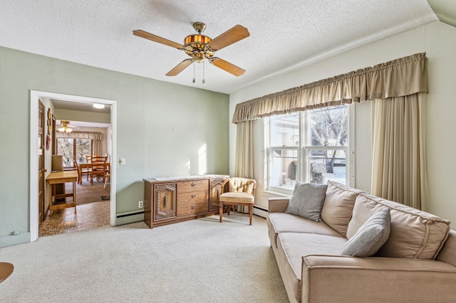 living room with ceiling fan, carpet flooring, a baseboard heating unit, and a textured ceiling