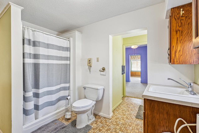 full bathroom with baseboards, curtained shower, toilet, a textured ceiling, and vanity