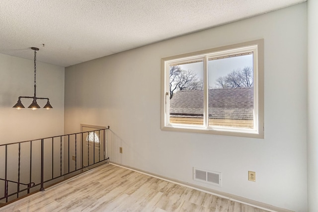 spare room featuring wood finished floors and a textured ceiling