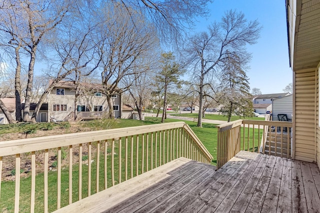 wooden terrace featuring a lawn and a residential view