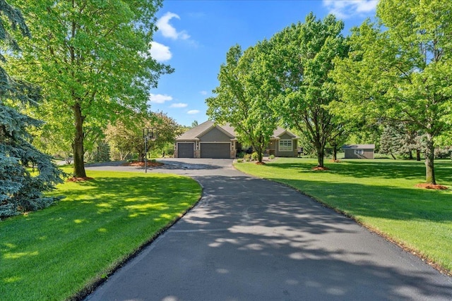 15210 Painters Lane Cir N, West Lakeland Twp, MN 55082 - obstructed view of property with asphalt driveway, a front yard, and a garage