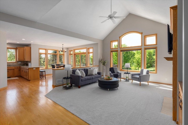 15210 Painters Lane Cir N, West Lakeland Twp, MN 55082 - living area featuring a chandelier, high vaulted ceiling, baseboards, a ceiling fan, and light wood-style floors