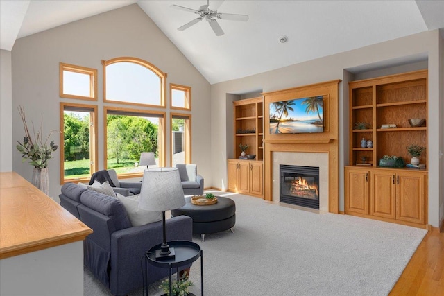 15210 Painters Lane Cir N, West Lakeland Twp, MN 55082 - living room featuring high vaulted ceiling, a tiled fireplace, a ceiling fan, and light wood-style flooring