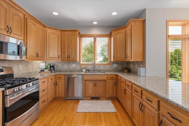 15210 Painters Lane Cir N, West Lakeland Twp, MN 55082 - kitchen featuring stainless steel appliances, a sink, light stone countertops, light wood finished floors, and recessed lighting