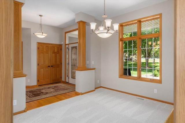 15210 Painters Lane Cir N, West Lakeland Twp, MN 55082 - foyer entrance featuring decorative columns, carpet flooring, a chandelier, and baseboards