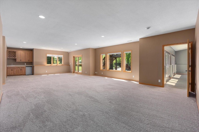 15210 Painters Lane Cir N, West Lakeland Twp, MN 55082 - unfurnished living room featuring recessed lighting, baseboards, light carpet, and bar area