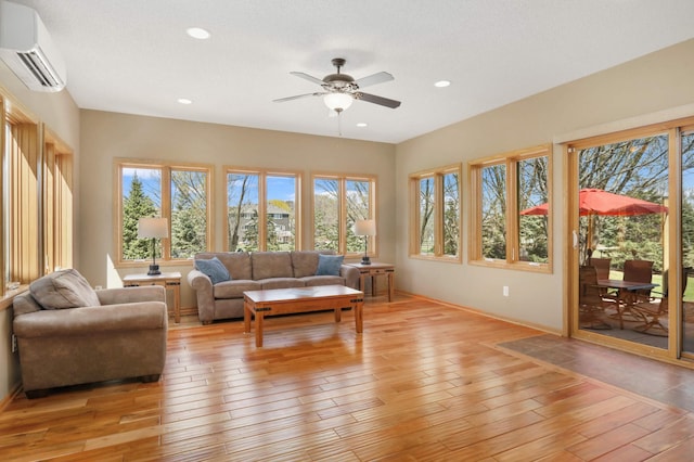 living room with recessed lighting, an AC wall unit, a ceiling fan, and light wood-style flooring