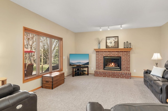 carpeted living area featuring track lighting, baseboards, and a fireplace