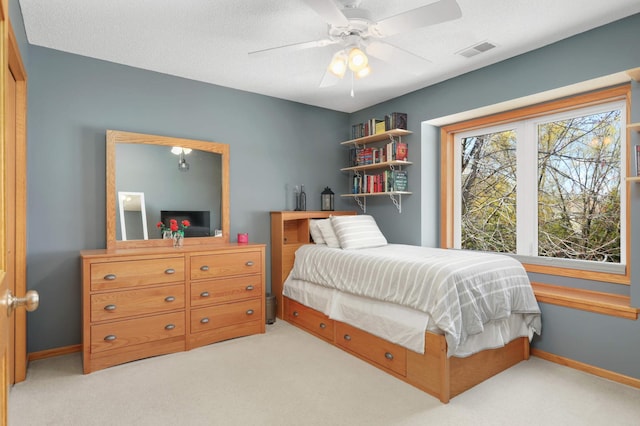 carpeted bedroom featuring visible vents, a ceiling fan, and baseboards